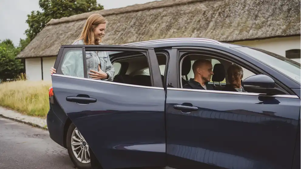 Kvinde stiger ind i passagerbil