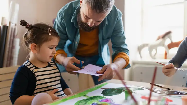 Pædagog laver aktivitet sammen med barn i dagtilbud