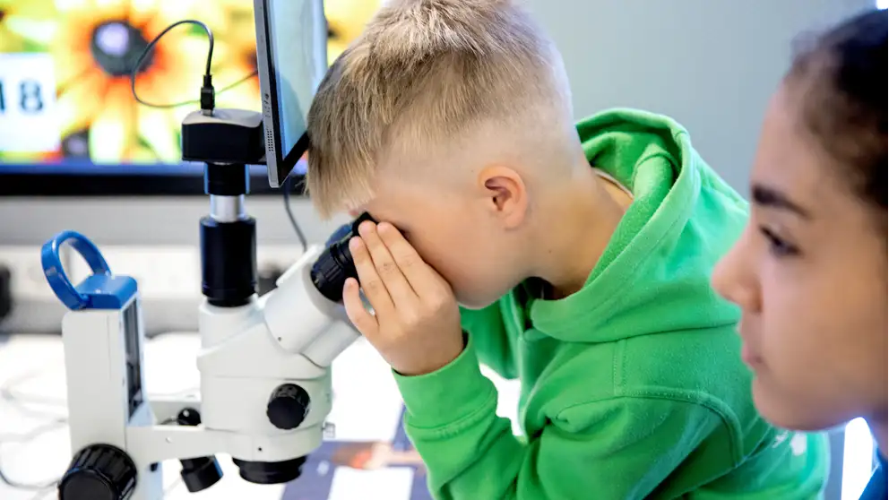 Dreng kigger i mikroskop