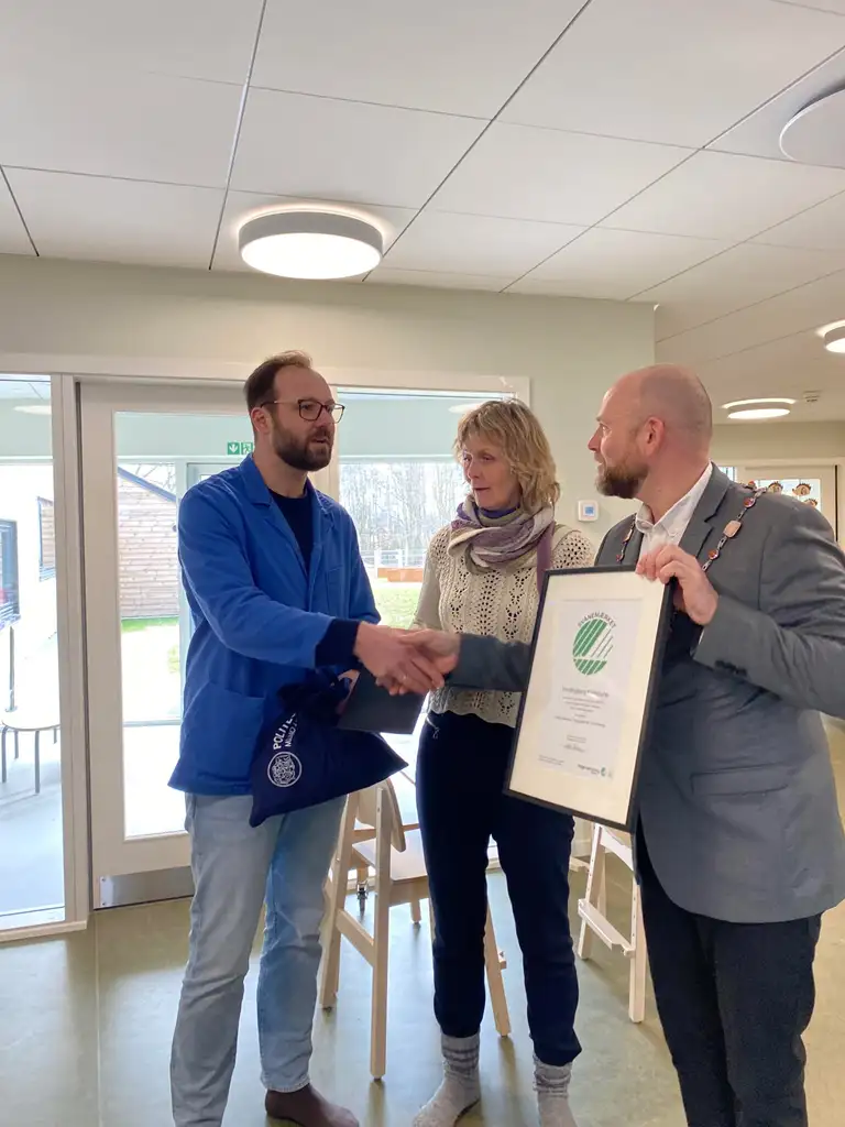 Bjørn-Erik Kölsch fra Miljømærkning Danmark overrækker de to certifikater til dagtilbudsleder i Præstø Børnehus, Laila Hertel Gunthel, og borgmester, Mikael Smed 