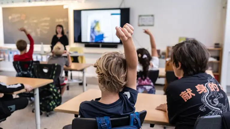 Barn rækker hånden i vejret