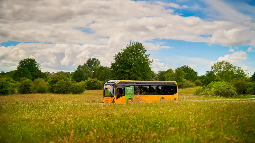 Billede af en Movia Bus der kører igennem landskabet