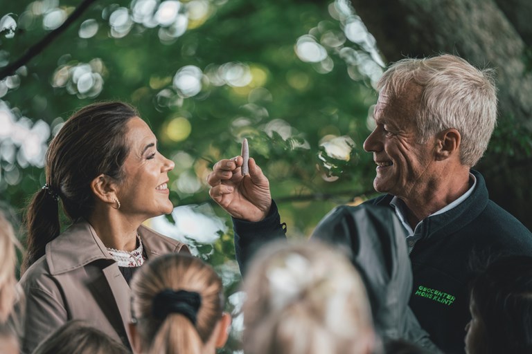 Direktør for Geocenter Møns Klint Nils Natorp viser H.M. Dronningen et fossil. Foto: Mads Tolstrup