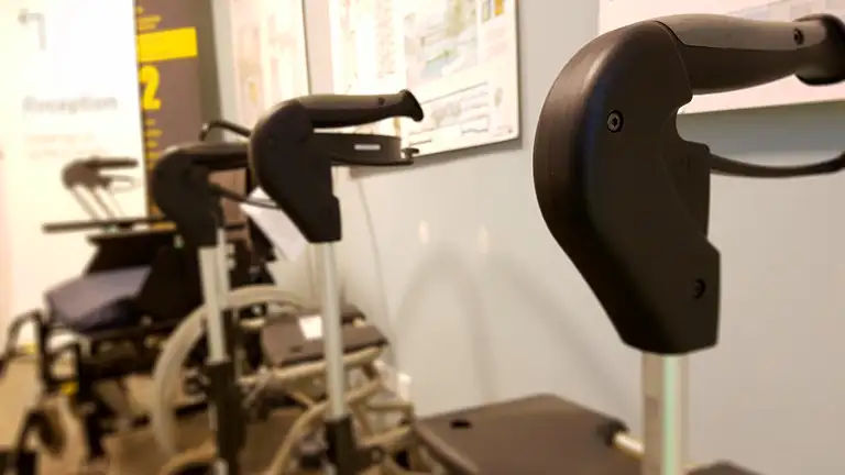 Billede af en række rollatorer og kørestole i en offentlig lignende bygning