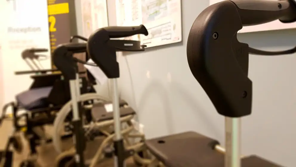 Billede af en række rollatorer og kørestole i en offentlig lignende bygning