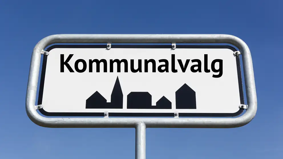 Billede af et byskilt med teksten "kommunalvalg" skrevet på