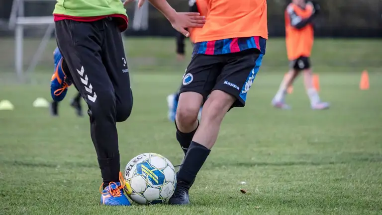 Drenge i løb, der spiller fodbold