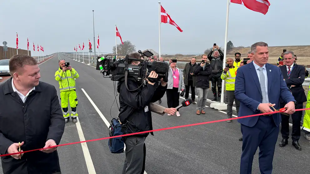 Billede af to mænd, der klipper et rødt bånd