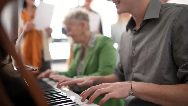 Mand og senior spiller klaver sammen